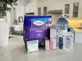 Zestaw produktów poporodowych: podpaski Tena, chusteczki Tucks, pianka do gojenia krocza Frida Mom, woda oczarowa i żel aloesowy.