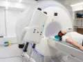 Pacjentka leży w aparacie do rezonansu magnetycznego, przygotowana do tomografii z kontrastem. Nawet przy przeziębieniu, diagnostyka jest kluczowa.