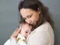 Mama tuli tulą do siebie dziecko, łagodząc lęk separacyjny u niemowlaka.