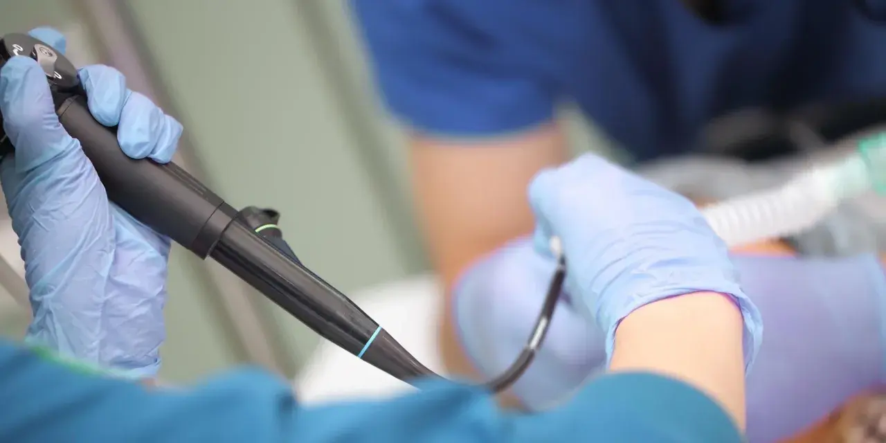 Lekarz w rękawiczkach przygotowuje się do gastroskopii. Czy gastroskopia boli? Znieczulenie i profesjonalizm lekarza minimalizują dyskomfort.