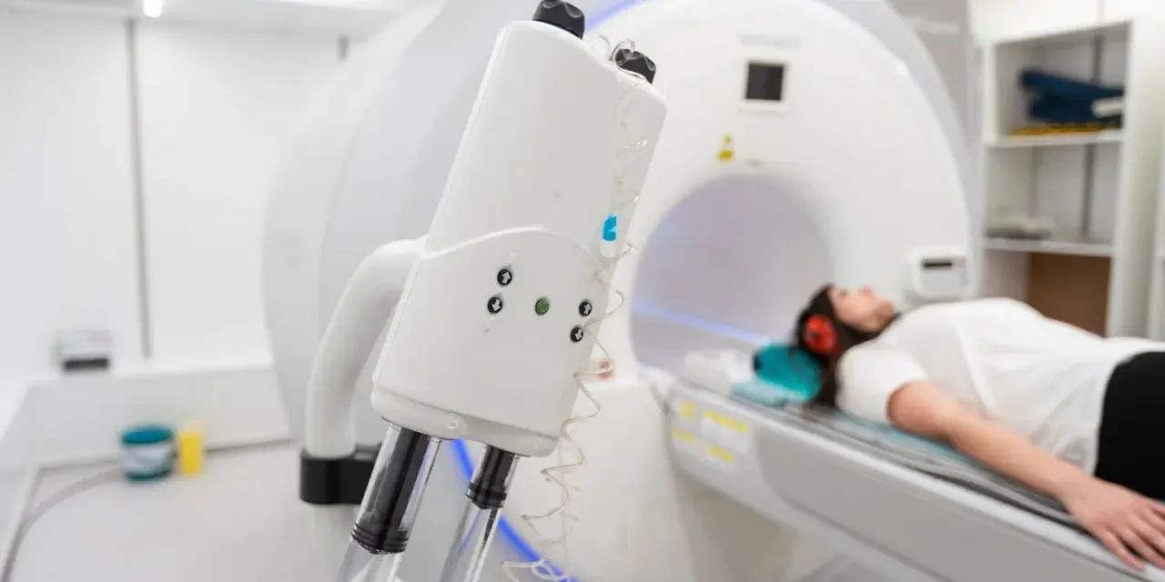Pacjentka leży w aparacie do rezonansu magnetycznego, przygotowana do tomografii z kontrastem. Nawet przy przeziębieniu, diagnostyka jest kluczowa.