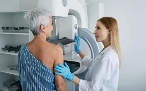 Lekarka przygotowuje pacjentkę do mammografii. Czy mammografia boli? To badanie jest kluczowe dla wczesnego wykrywania raka piersi.