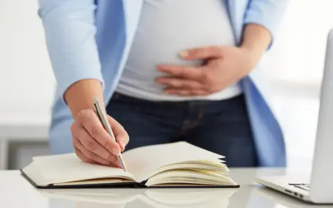 Kobieta w ciąży tworzy swój plan porodu wzór, notując ważne szczegóły.