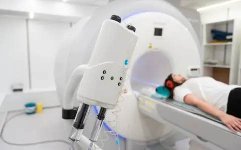 Pacjentka leży w aparacie do rezonansu magnetycznego, przygotowana do tomografii z kontrastem. Nawet przy przeziębieniu, diagnostyka jest kluczowa.