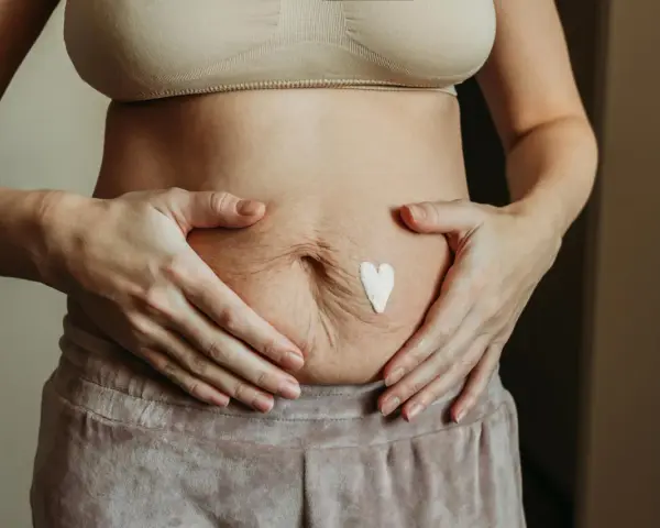 Brzuch po ciąży z sercem z kremu. Warto pamiętać o kontrolach, jakie badania po ciąży są ważne dla zdrowia.