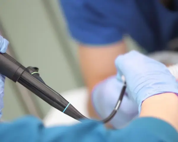 Lekarz w rękawiczkach przygotowuje się do gastroskopii. Czy gastroskopia boli? Znieczulenie i profesjonalizm lekarza minimalizują dyskomfort.