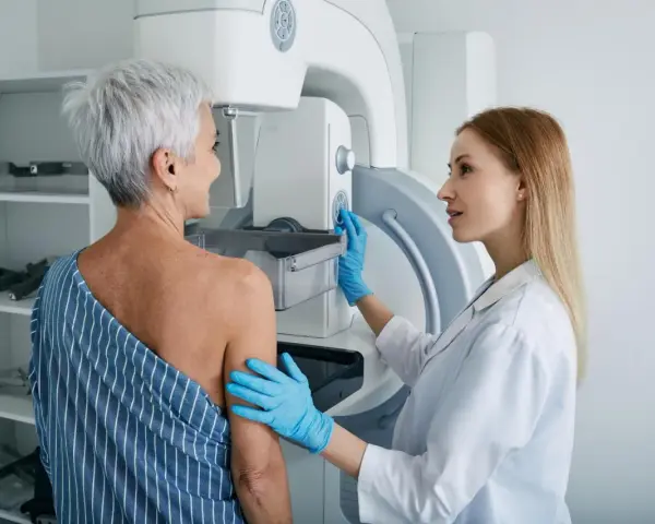 Lekarka przygotowuje pacjentkę do mammografii. Czy mammografia boli? To badanie jest kluczowe dla wczesnego wykrywania raka piersi.