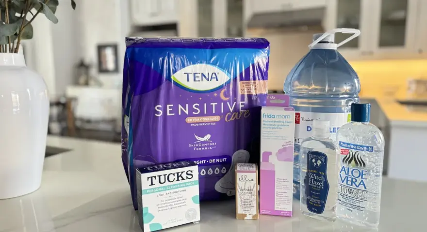 Zestaw produktów poporodowych: podpaski Tena, chusteczki Tucks, pianka do gojenia krocza Frida Mom, woda oczarowa i żel aloesowy.