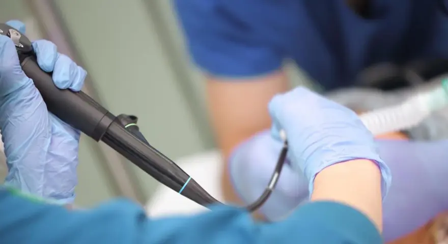 Lekarz w rękawiczkach przygotowuje się do gastroskopii. Czy gastroskopia boli? Znieczulenie i profesjonalizm lekarza minimalizują dyskomfort.