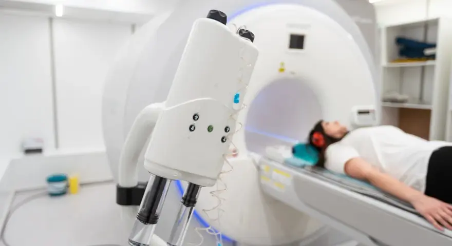 Pacjentka leży w aparacie do rezonansu magnetycznego, przygotowana do tomografii z kontrastem. Nawet przy przeziębieniu, diagnostyka jest kluczowa.