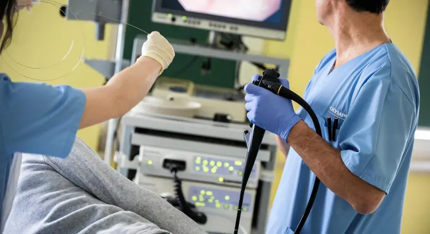 Lekarz wykonuje kolonoskopię, badanie kluczowe dla diagnostyki. Czy kolonoskopia jest bezpieczna? Tak, przy odpowiednim przygotowaniu i wykonaniu.