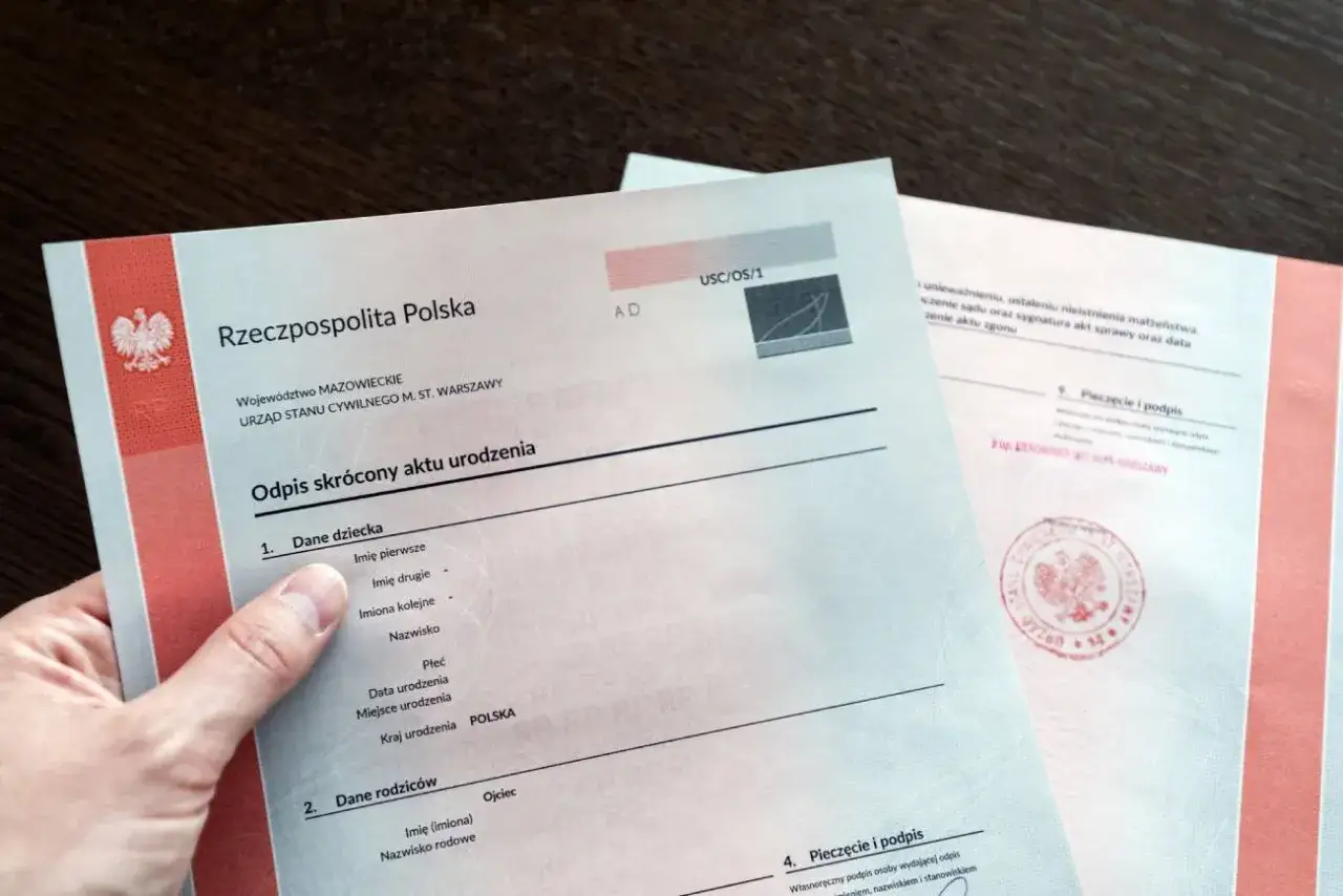 Urzędnik USC w Warszawie wydaje odpis skrócony aktu urodzenia. Dokument zawiera dane dziecka i rodziców.
