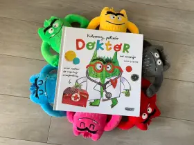Kolorowy potwór Doktor od emocji, otoczony pluszowymi potworami, czeka na przedszkole.